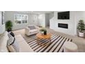 Bright living room featuring a decorative fireplace, sleek furniture, and a modern striped rug at 13813 N Hawkers Hill Dr, Camby, IN 46113