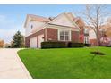 View of side of home with brick and siding, manicured lawn, and two car garage at 13933 Wildcat Dr, Carmel, IN 46033