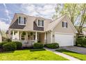 Charming two-story home featuring a covered porch, manicured lawn, and a two-car garage at 15037 Rutherford Dr, Westfield, IN 46074