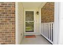 Close up of front porch with detailed brickwork, modern lighting fixture, and welcoming features at 1520 Norfolk Dr, Zionsville, IN 46077