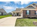 A well-kept lawn leads to this house with mixed brick and gray siding, with a two car garage at 15781 Harvester E Cir, Noblesville, IN 46060
