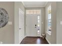Bright entryway features a white door, hardwood floors, a decorative wall hanging, and trim at 15781 Harvester E Cir, Noblesville, IN 46060