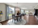 Open-concept living room with hardwood flooring, a chandelier, and large windows providing plenty of natural light at 15781 Harvester E Cir, Noblesville, IN 46060