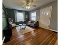 Comfortable living room with hardwood floors, large windows, and a stylish gray sofa at 1624 N Whittier Pl, Indianapolis, IN 46218