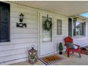Charming porch features a wreath, red chair, lantern, and a 'Hello' door mat at 1629 N K St, Elwood, IN 46036