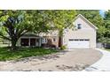 Inviting home featuring a side-entry garage, covered porch, and lush greenery on a sunny day at 244 W Admiral S Way, Carmel, IN 46032