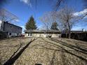 The backyard with leafless trees provides shade and the exterior of the home offers a back door and a set of French doors at 3642 Horth Ct, Indianapolis, IN 46235