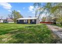Cozy house on a spacious lot featuring a large yard, mature trees, and ample space for outdoor activities at 415 Elm Ave, Sheridan, IN 46069