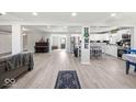 Spacious open-concept living area with modern flooring seamlessly connects the living, dining, and kitchen spaces at 415 Elm Ave, Sheridan, IN 46069