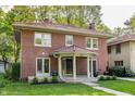 Attractive brick house with a red tile roof, covered entryway, and lush green lawn at 4343 N Pennsylvania St, Indianapolis, IN 46205