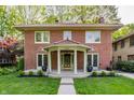 Charming two-story brick home featuring a red tile roof, covered porch, and well-manicured lawn at 4343 N Pennsylvania St, Indianapolis, IN 46205