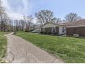 Charming home nestled on a grassy lot with mature trees and a side driveway at 4412 Mountbatten Ct, Indianapolis, IN 46254