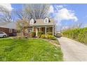 Charming home with lush landscaping and a driveway leading to the backyard at 4640 Boulevard Pl, Indianapolis, IN 46208