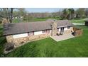 Aerial view of a backyard featuring a stone patio with outdoor seating and well-maintained lawn at 5210 S 100 E Rd, Anderson, IN 46013