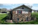 A stone-accented home featuring well-maintained landscaping and updated windows at 5210 S 100 E Rd, Anderson, IN 46013