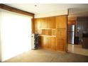 Bright living area with built-in wooden cabinets, carpeted flooring, and a view into the adjacent kitchen space at 5363 Channing Rd, Indianapolis, IN 46226