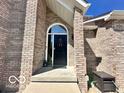 Arched entryway featuring a black front door with brick surround and concrete step at 6036 Chinkapin Dr, Columbus, IN 47201
