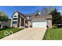 Charming two-story brick home featuring a well-manicured lawn and attached two car garage at 6036 Chinkapin Dr, Columbus, IN 47201