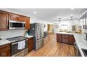 Modern kitchen with stainless steel appliances, wood cabinets, and marble countertops leading to the dining area at 6150 Red Day Rd, Martinsville, IN 46151