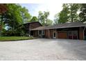 Exterior view of a well-maintained home featuring a brick facade, attached garage, and spacious gravel driveway at 701 E Main St, Westfield, IN 46074