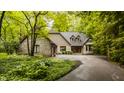 Charming brick home with mature trees, landscaping, and a circular driveway at 7249 Tuliptree Trl, Indianapolis, IN 46256