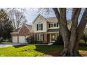Traditional two-story home with brick and siding, set on a lush green lawn with mature trees, and a spacious two-car garage at 757 Howe Dr, Carmel, IN 46032