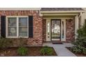 Close-up of the home's entrance, highlighting the brick facade, a window with shutters, and a welcoming front door at 757 Howe Dr, Carmel, IN 46032