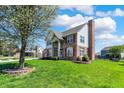 Two-story house with brick, shutters and a well-manicured lawn with some trees and a chimney at 7637 Sand Run Ct, Indianapolis, IN 46259
