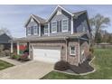 Attractive two-story home featuring blue siding, brick details, and attached two car garage at 8926 New Heritage Ct, Indianapolis, IN 46239