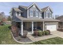 Charming exterior view showcasing a two-story home with a covered front porch and manicured lawn at 8926 New Heritage Ct, Indianapolis, IN 46239