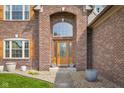Inviting home entrance with arched entryway, glass door, and landscaped surroundings at 1121 Retford Ct, Greenwood, IN 46143