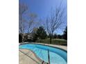 Sparkling blue in-ground swimming pool surrounded by a concrete deck and mature trees, perfect for relaxation and recreation at 1121 Retford Ct, Greenwood, IN 46143