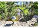 Picturesque backyard creek view, accented by stone features and abundant greenery at 11625 Rolling Springs Dr, Carmel, IN 46033