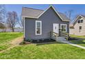 Charming gray home with a well-maintained lawn and inviting walkway leading to the front door at 1217 W 6Th St, Anderson, IN 46016