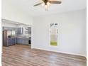 Bright living room featuring light walls, wood floors, and a ceiling fan; kitchen visible in background at 1217 W 6Th St, Anderson, IN 46016