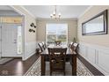 Dining room showing a wood table, chair set, wainscoting, modern chandelier, and ample natural light at 1334 Winfield Way, Greenwood, IN 46143