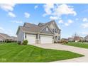 Angle view of an elegant two-story home with a three-car garage and a well-maintained lawn in a residential neighborhood at 1334 Winfield Way, Greenwood, IN 46143