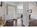 Inviting foyer featuring hardwood floors and white wainscoting with views to the dining area at 1334 Winfield Way, Greenwood, IN 46143