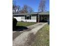 Exterior shot featuring a long gravel driveway leading to a house with an attached carport and partial lawn view at 1618 E 24Th St, Muncie, IN 47302