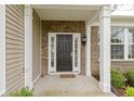 Close-up of the front door with decorative brickwork, white pillars and a welcome mat at 16243 Oliver St, Fishers, IN 46037