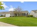 Inviting single-story home with a well-kept lawn and a two-car attached garage at 16243 Oliver St, Fishers, IN 46037