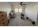 Spacious room featuring neutral carpet, a ceiling fan, and weightlifting equipment at 1833 Southernwood Ln, Indianapolis, IN 46231