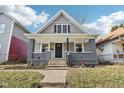 Well-maintained home featuring gray siding, a covered porch, and landscaped front yard at 2114 N Dexter St, Indianapolis, IN 46202