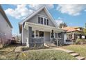 Charming home with gray siding, a covered porch, and a small front yard at 2114 N Dexter St, Indianapolis, IN 46202