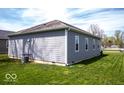 Spacious backyard with a well-maintained lawn and a view of the home's exterior at 2239 E Werges Ave, Indianapolis, IN 46237