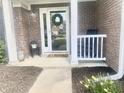 Inviting front porch with a decorative wreath, rocking chair, and flower arrangements, creating a welcoming entrance at 2303 Cole Wood Ct, Indianapolis, IN 46239