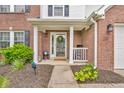Charming front porch with brick columns, a decorative wreath, and a welcoming seating area and landscaping at 2303 Cole Wood Ct, Indianapolis, IN 46239