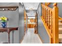 Inviting hallway with neutral gray walls, tile flooring, and a wooden staircase leading to the upper level at 2303 Cole Wood Ct, Indianapolis, IN 46239