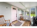 Inviting front porch with rocking chairs and a charming pink front door at 3335 W 400 N, Anderson, IN 46011