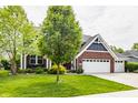 Charming two-story home featuring a brick and blue facade, complemented by a well-manicured lawn at 3640 Snowdon Dr, Westfield, IN 46074